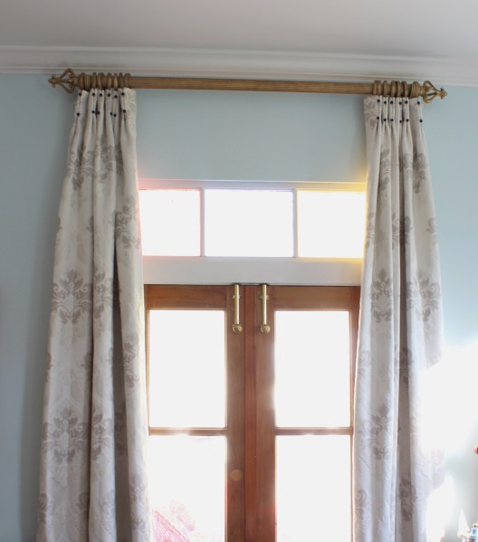 cream drapes with inverted pleats and navy covered buttons